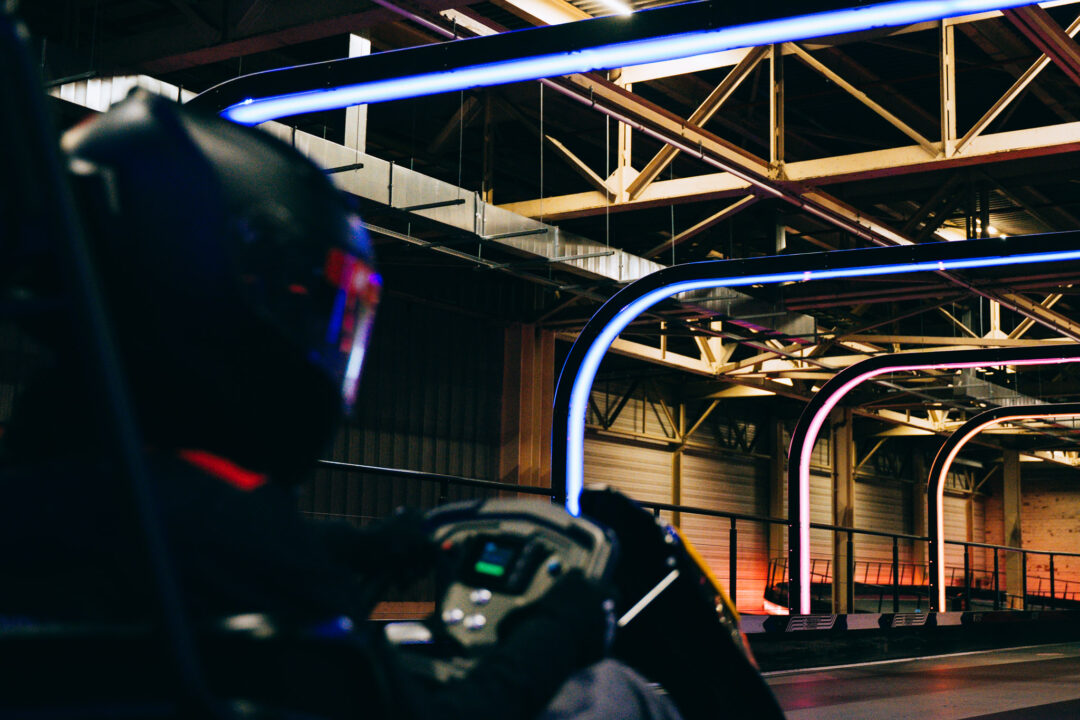 Driver in a kart wearing a helmet at Experience Factory Antwerp